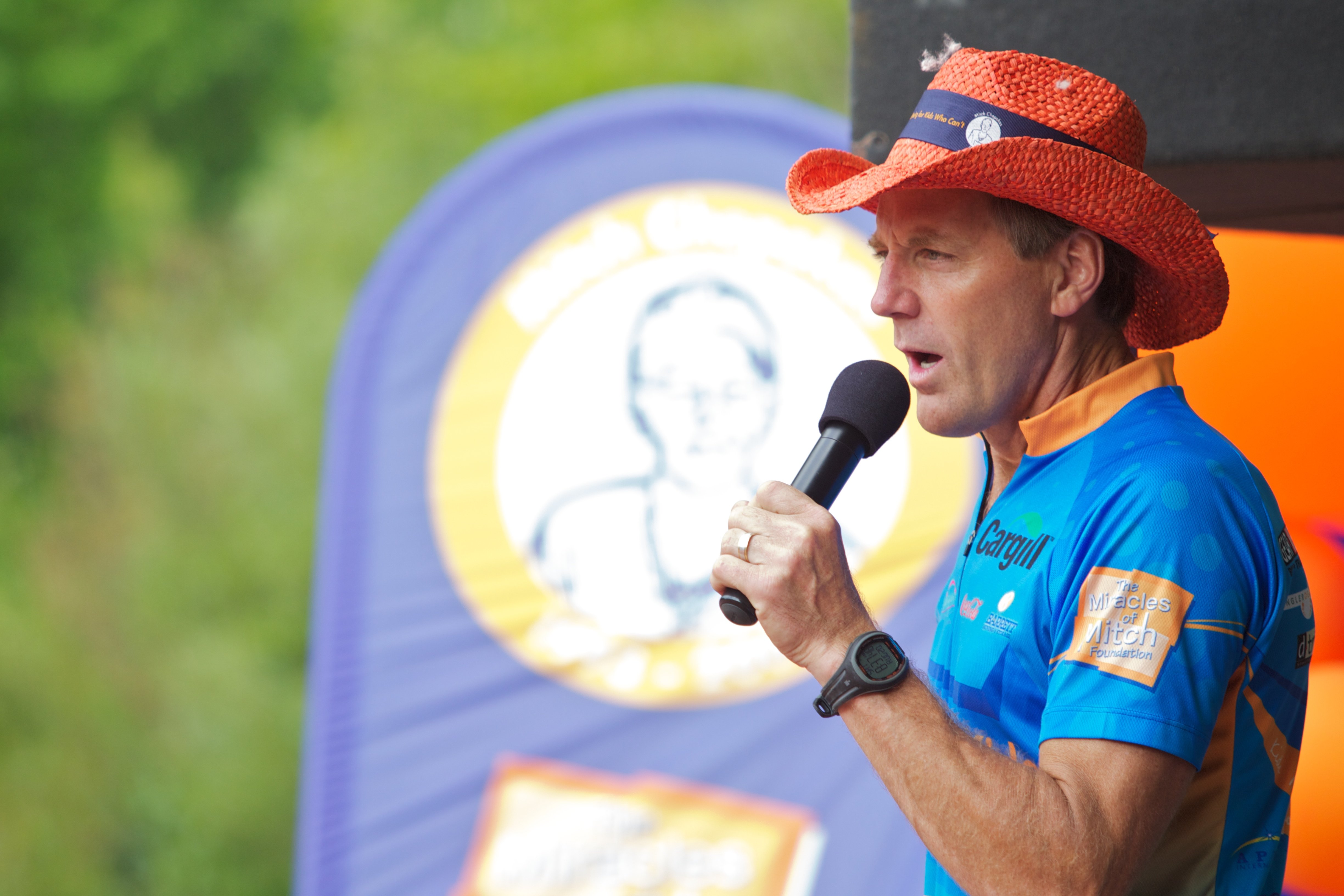 A man speaking at a Miracles of Mitch kids triathlon in 2011. Miracles of Mitch is now Pinky Swear Foundation.
