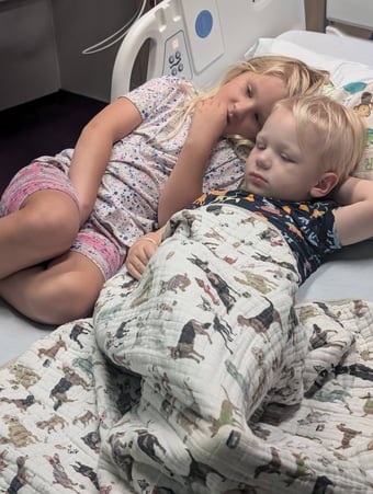 Shepherd and sister lying in the hospital bed