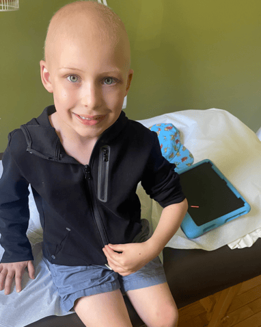 A boy named Toby facing acute lymphoblastic leukemia in the hospital holding his arm for the doctor