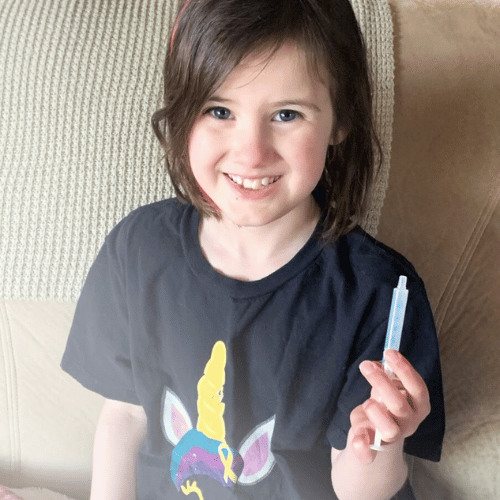 All-Star Harper holding up her meds while sitting on the couch