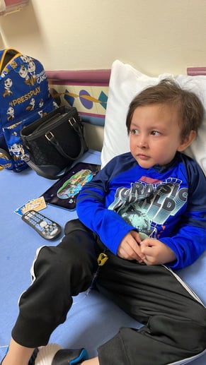 A child with leukemia during a clinic visit sitting down