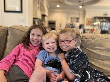 Three kids sitting on a couch. These are Pinky Swear board member Mike Hirschberg's kids