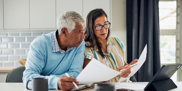 Two people looking at some documents for retirement as they consider supporting the charity of their choice with their IRA contributions.