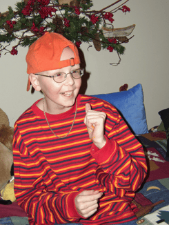 The founder of Pinky Swear Foundation, Mitch wearing an orange striped shirt and a baseball cap backwards.