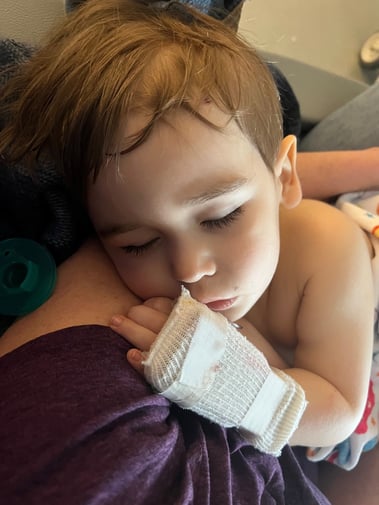 Greyson sleeping with mom, hand bandaged