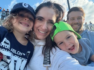 A selfie of Katie and her family outside on a sunny day.