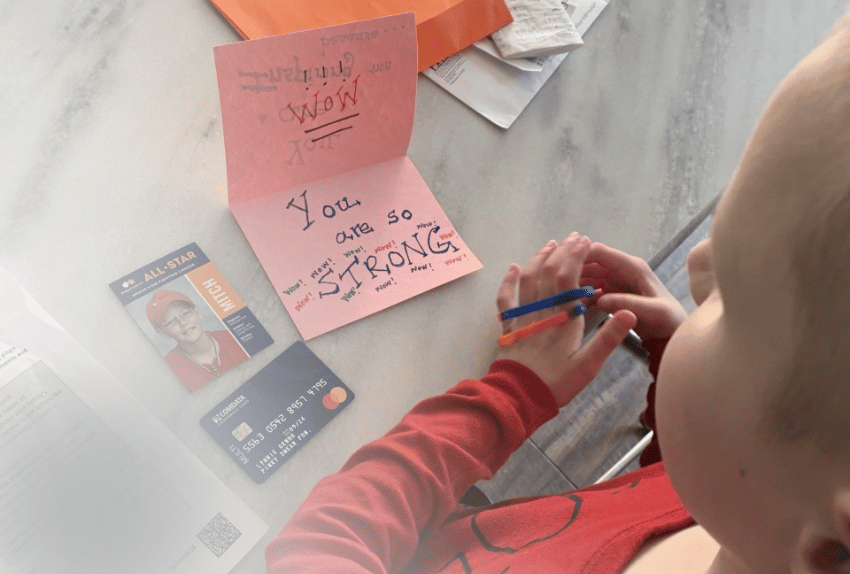 All-Star Anne reading her Letter of Encouragement from a Pinky Swear volunteer while opening her Orange Envelope