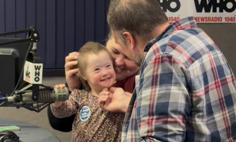 A little girl smiling at her dad while on the radio with WHO during the Pinky Swear Radiothon in 2025