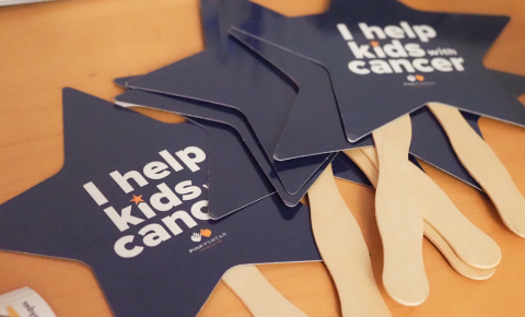 I help kids with cancer handheld signs on a table