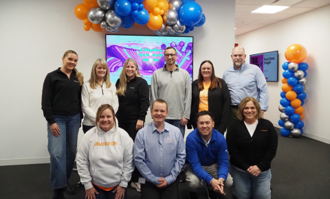 A large group of volunteers standing under a balloon tier at the Pinky Swear Radiothon in 2025
