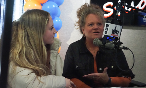 A mom sharing her daughter's childhood cancer story next to her on WHO Radio during the Pinky Swear Foundation Radiothon in 2024.
