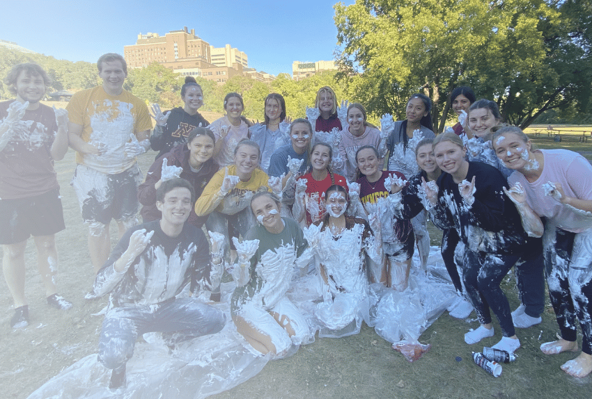 A group of college students covered in whipped cream after a Cancer is Messy event to raise money for Pinky Swear