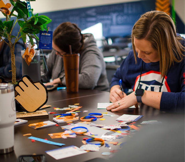 A Geneva Capital employee making a letter of encouragement for kids with cancer