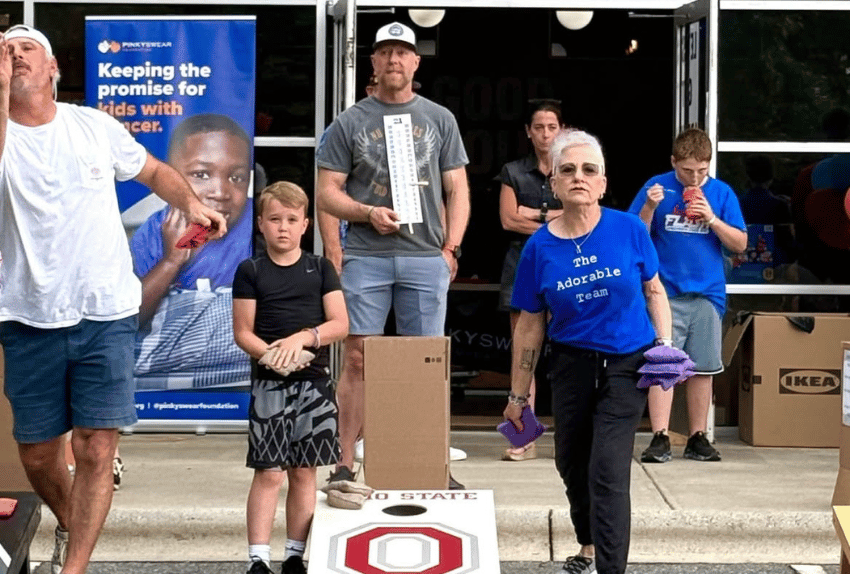 A group of people playing cornhole.