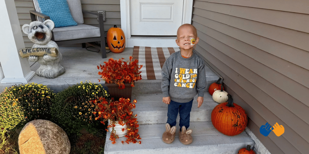 A little boy named gryffin standing on his front steps wearing a shirt that says 