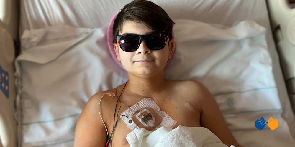 A boy named River in the hospital wearing sunglasses