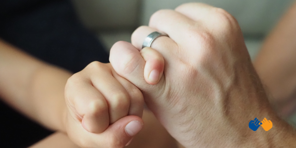 Two people doing a pinky swear representing Pinky Swear Foundation, a nonprofit that helps kids with cancer and their families financially with everyday expenses like housing, food, and transportation.